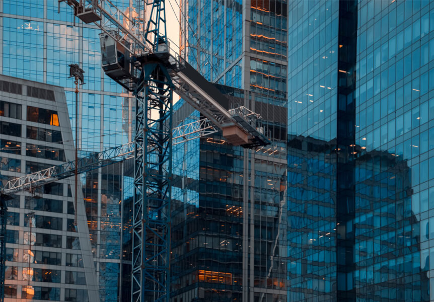 An image of downtown in a city with skyscrapers and a large crane in the centre